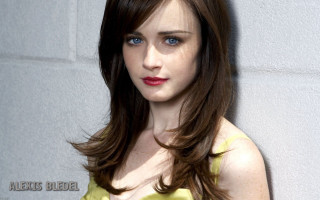 Woman blue eyes yellow dress - a white wall behind her free wallpaper