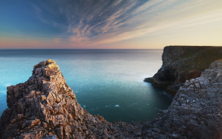 Rocky cliff water sky boat - a body of water below free wallpaper