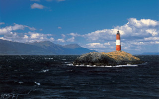 Lighthouse island ocean mountains clouds - a small island in the middle of the ocean free wallpaper