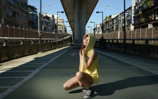 Woman yellow dress sitting urban - her hand behind her head free wallpaper