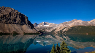 Mountain lake reflection bridge city - a mountain range in the background free wallpaper