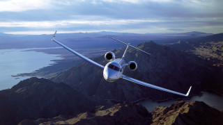 Small plane over mountains lake - over a mountain range free wallpaper