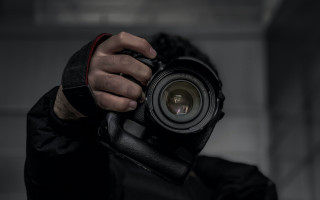 Man holding camera dark room 2 - the len free wallpaper