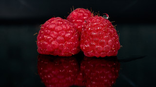 Three raspberries black surface reflection - a black surface free wallpaper