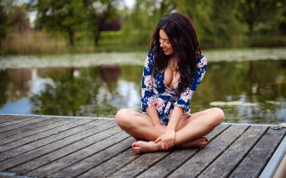 Woman sitting dock water blurry - her shirt open free wallpaper