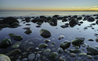 Beach rocks water lighthouse sunset - a lighthouse in the distance free wallpaper