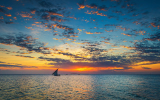Sailboat ocean sunset island sky - a small island in the distance free wallpaper