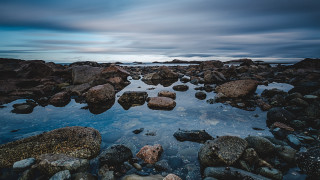 Rocky beach water boulders cloudy - evaline ness free wallpaper