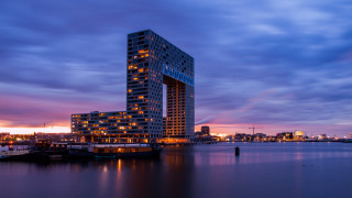 Tall building water night city - a city in the background and a boat free wallpaper