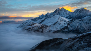 Snowy mountain range clouds sunset - a few cloud below free wallpaper