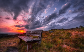 Bench hillside grass sunset cloudy - the sun setting free wallpaper