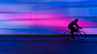 Man bike street tallbuilding colorfulsky - a colorful sky in the background free wallpaper