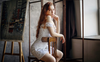 Woman sitting painting easel thoughtful - a chair in front free wallpaper