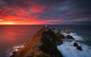 Lighthouse cliff ocean sunset red 2 - a red sky above free wallpaper