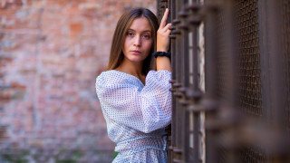 Woman fence serious portrait blurry - a woman leaning against a fence free wallpaper