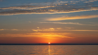 Sunset water boat clouds horizon - a boat in the distance free wallpaper