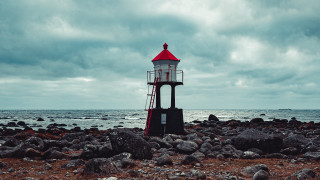 Lighthouse rocky beach cloudy sky - a lighthouse free wallpaper