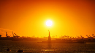 Water sunset statue liberty mountain - a large body of water free wallpaper