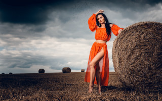 Woman orange dress haybale cloudy - a cloudy sky free wallpaper