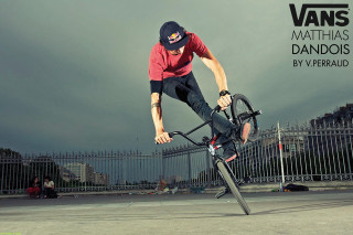 Man riding bike cement ground - a black fence free wallpaper