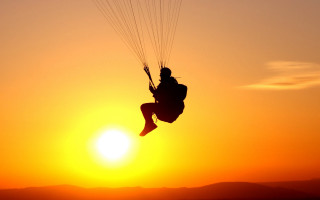 Paragliding sunset mountain ocean silhouette - a mountain range in the background free wallpaper