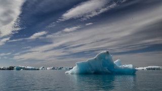 Iceberg floating lake cloudy sky - the water below free wallpaper