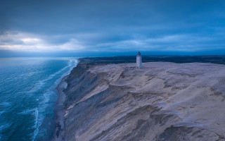 Lighthouse cliff ocean cloudy sky - carl hoppe free wallpaper