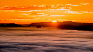 Sunset mountain range clouds orange - a sunset over a mountain range free wallpaper