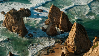Rocky beach waves person cave - a bunch of rocks free wallpaper