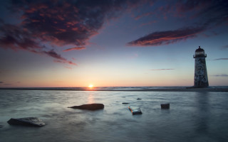 Lighthouse beach sunset rocks water - the foreground and a body of water free wallpaper