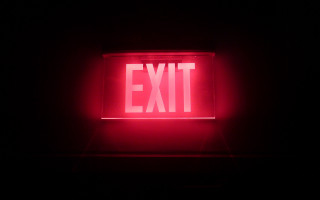Red exit sign dark lit - a photo free wallpaper