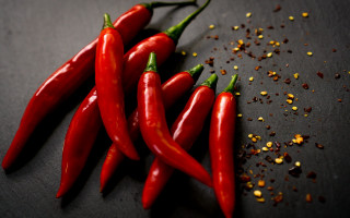 Red peppers spices black surface - a black surface free wallpaper