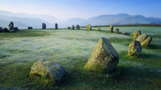 Field rocks mountains foggy sky - the middle of it free wallpaper