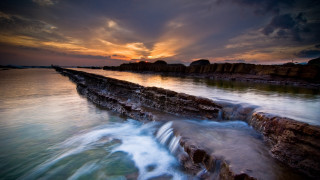 Sunset water rocks boat city - the foreground and a body of water free wallpaper