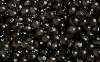 Black beads closeup tabletop background - a white spot free wallpaper