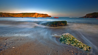 Rock water boat sunset wave - a boat in the background free wallpaper