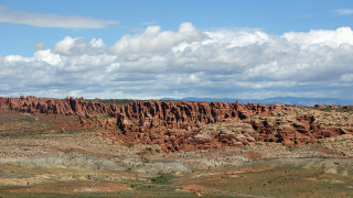 Desert rock formation sky clouds 2 - a large rock formation in the middle of a desert area free wallpaper