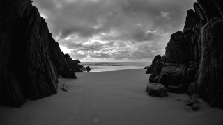Person sitting rock beach ocean - bedwyr williams free wallpaper