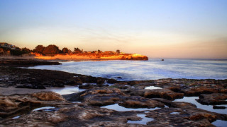 Beach rocky shore houses sunset - a rocky shore line free wallpaper