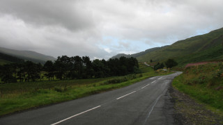 Road curved hill trees lake - a curve in the middle of it free wallpaper