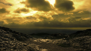Dirt path mountain cloudy sky - a sunbeam in the distance free wallpaper