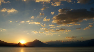 Sunset mountain range clouds sun - a sunset over a mountain range free wallpaper