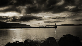 Lighthouse rocky shore cloudy sky 4 - a lighthouse in the distance free wallpaper