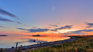 Sunset water fence hill cityscape - a sunset over a body of water free wallpaper