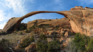 Large rock arch forest mountain - a large rock formation free wallpaper