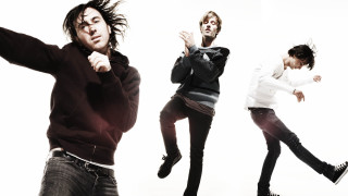 Three men jumping arms outstretched - their leg free wallpaper