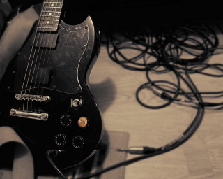 Black guitar wooden floor wires - a black guitar free wallpaper