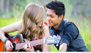 Man woman grass playing guitar 3 - a guitar free wallpaper