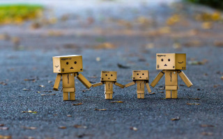 Cardboard figures holding hands road - the ground behind them free wallpaper