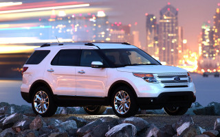 White suv rocky beach night - a city skyline in the background free wallpaper